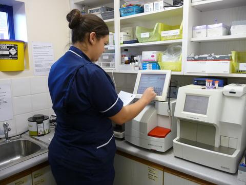 Anley runs the sample through the blood analyser in the practice laboratory, under careful supervision.