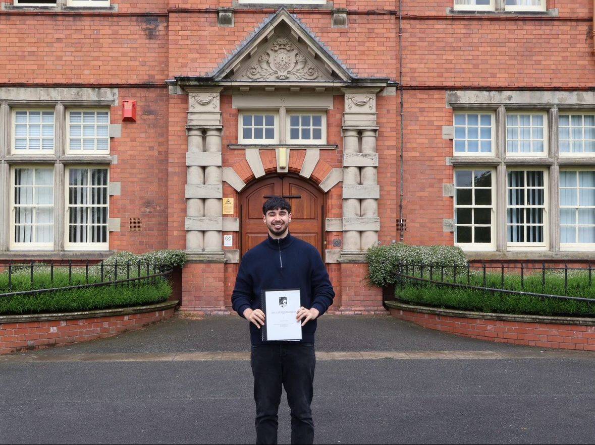 Fin Davies with his dissertation outside Main Building