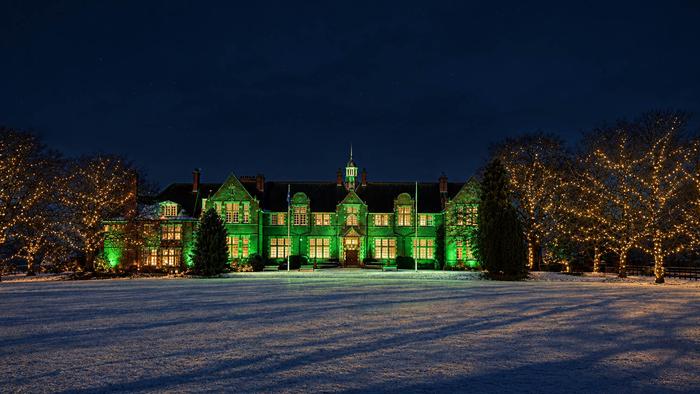 Harper Adams University's Foundation House lit up green in a snowy atmosphere
