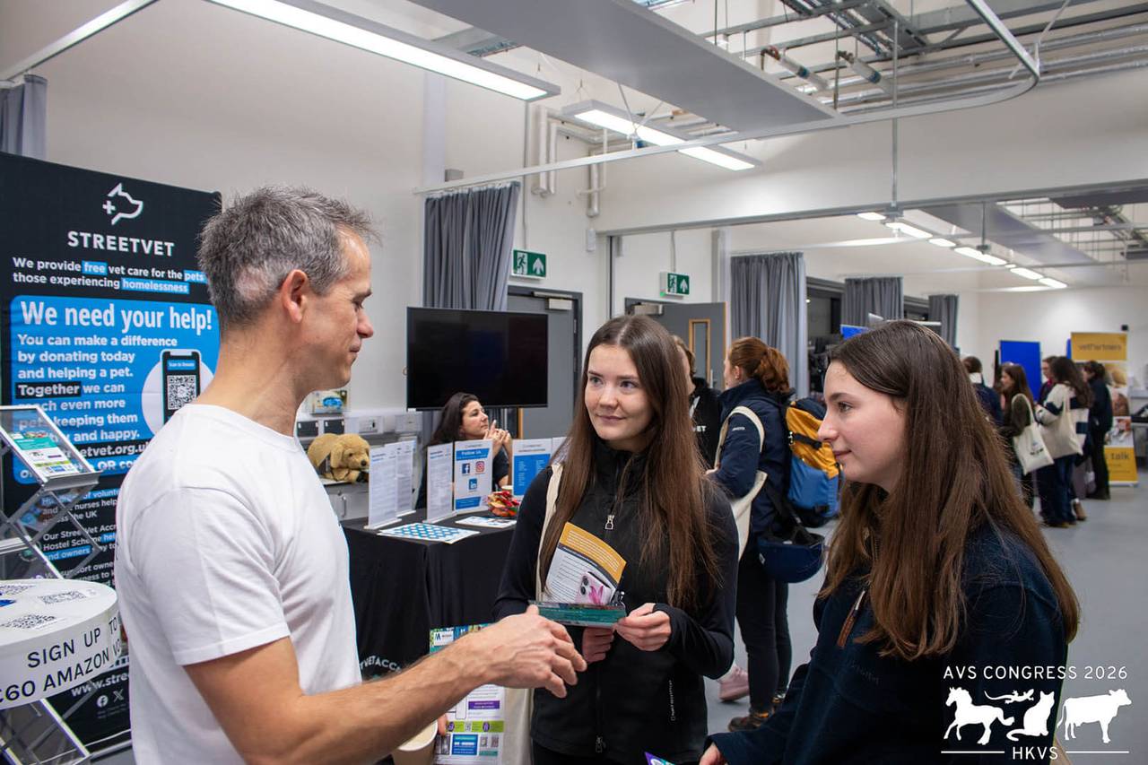 A representative from StreetVet talking to two AVS attendees. 